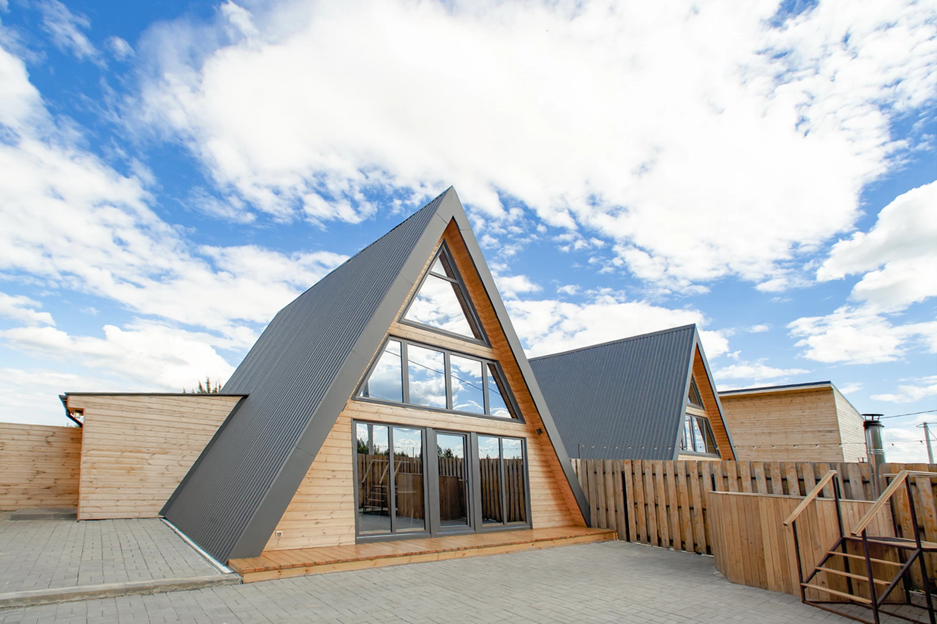 Во двор можно выйти как через входную дверь в боковой пристройке дома, так и через панорамное остекление, ведущее в зону с горячим чаном.