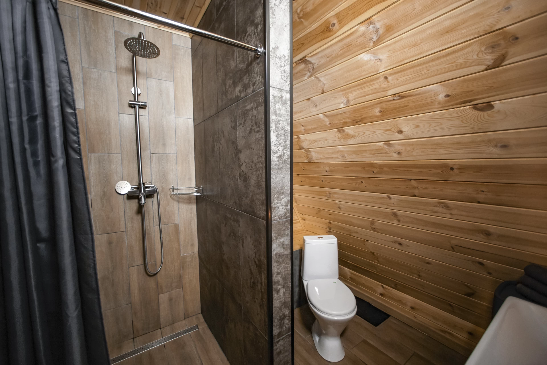 Душ оснащен системой слива, классической сантехникой, встроенным дозатором для геля и полочкой. Облицован противоскользящей плиткой.