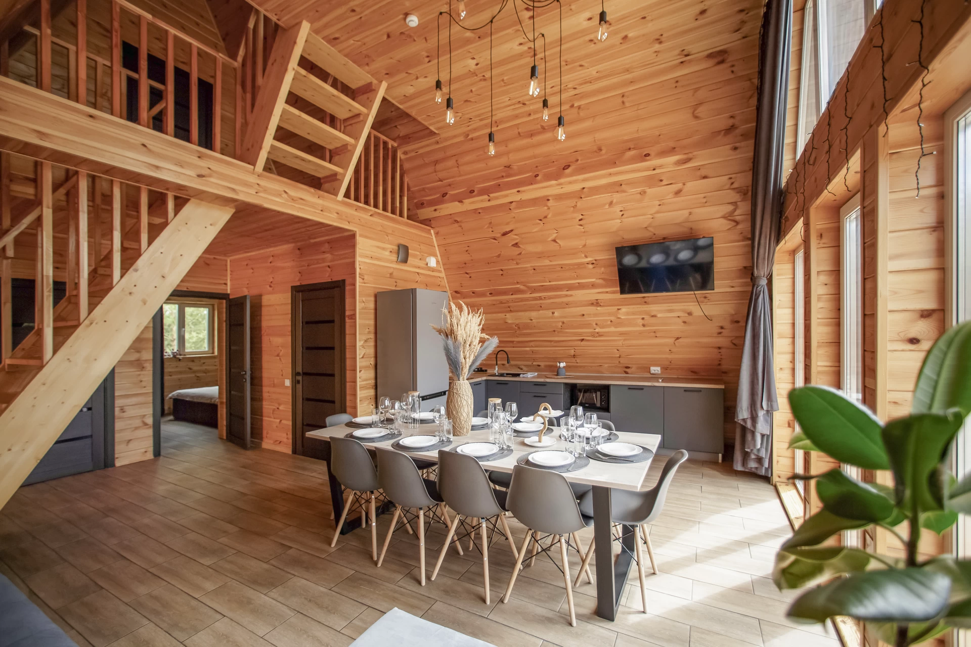 Главная комната, объединяющая гостиную и кухонную зону, подходит для неспешного отдыха, праздничного застолья или вечеринки.