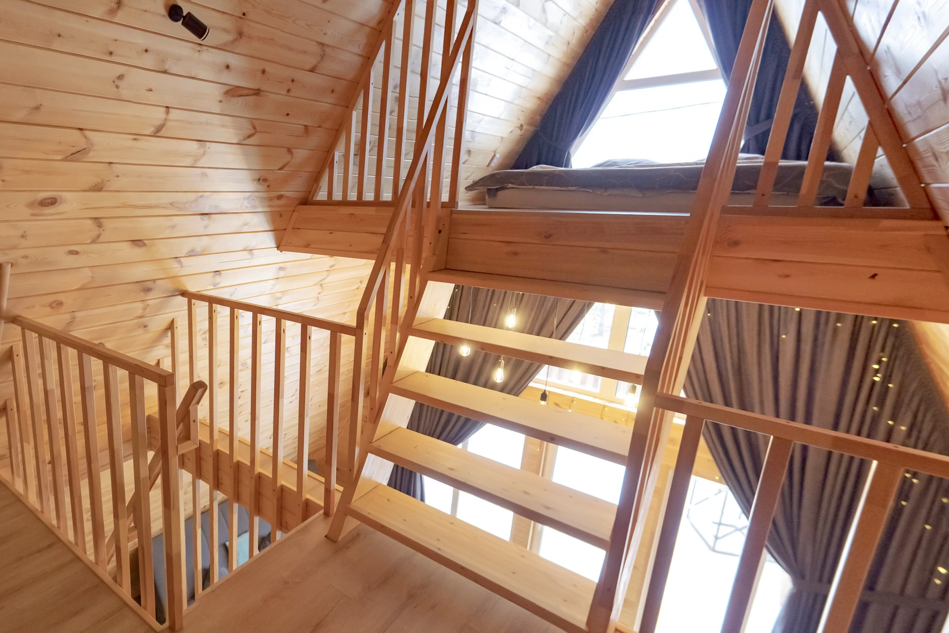 Уникальная зона отдыха под крышей с панорамным окном и мягкой зоной, которая выдержана в стилистике спальных комнат.